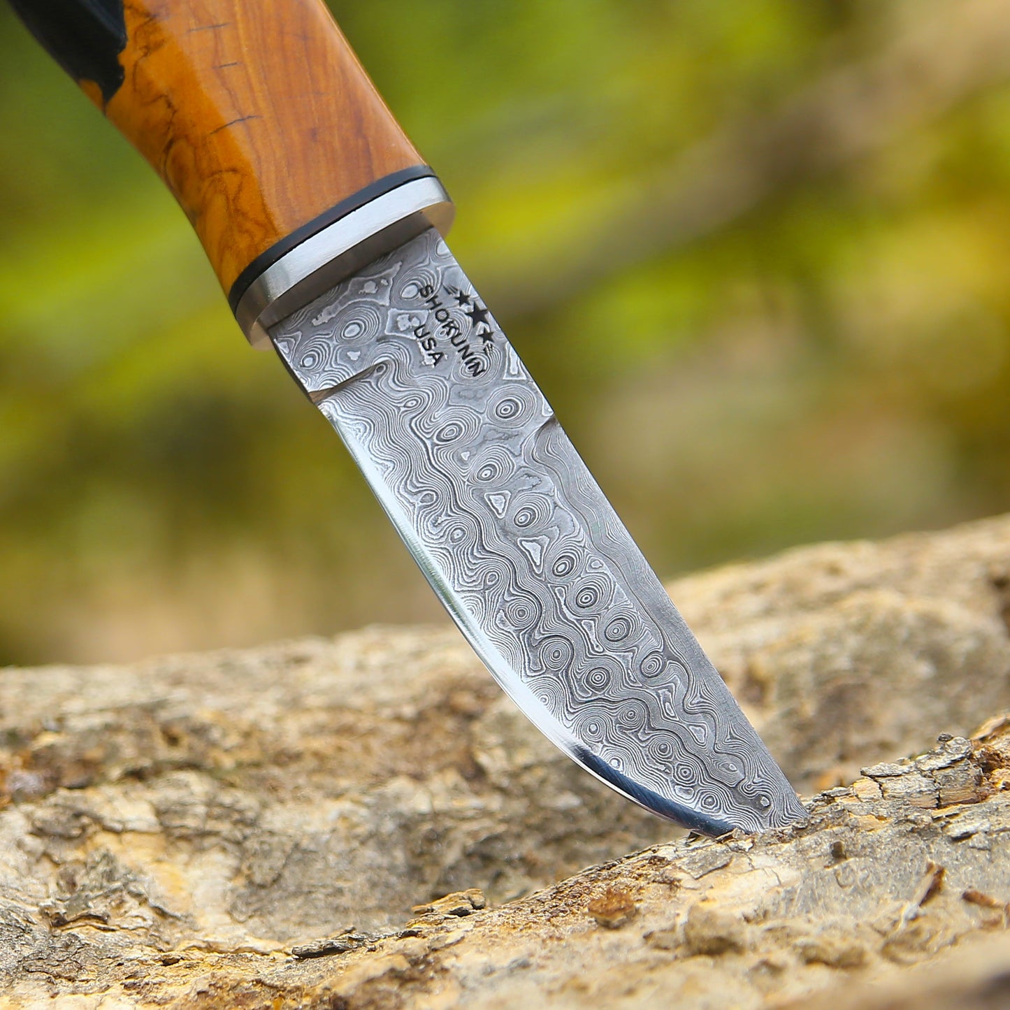 Decorative knife with a wooden handle on a natural rock background